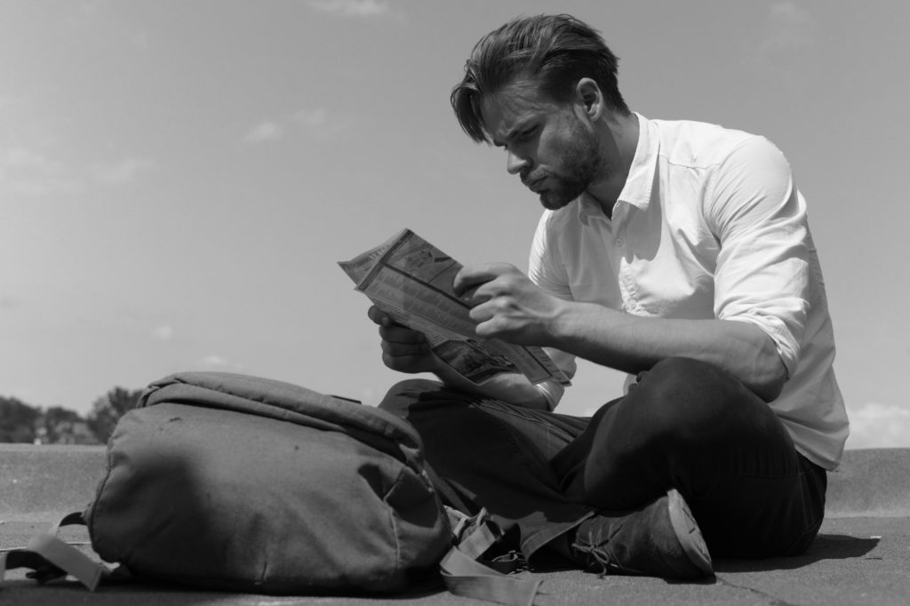 Tourists got lost, sits looking at his map or guide.